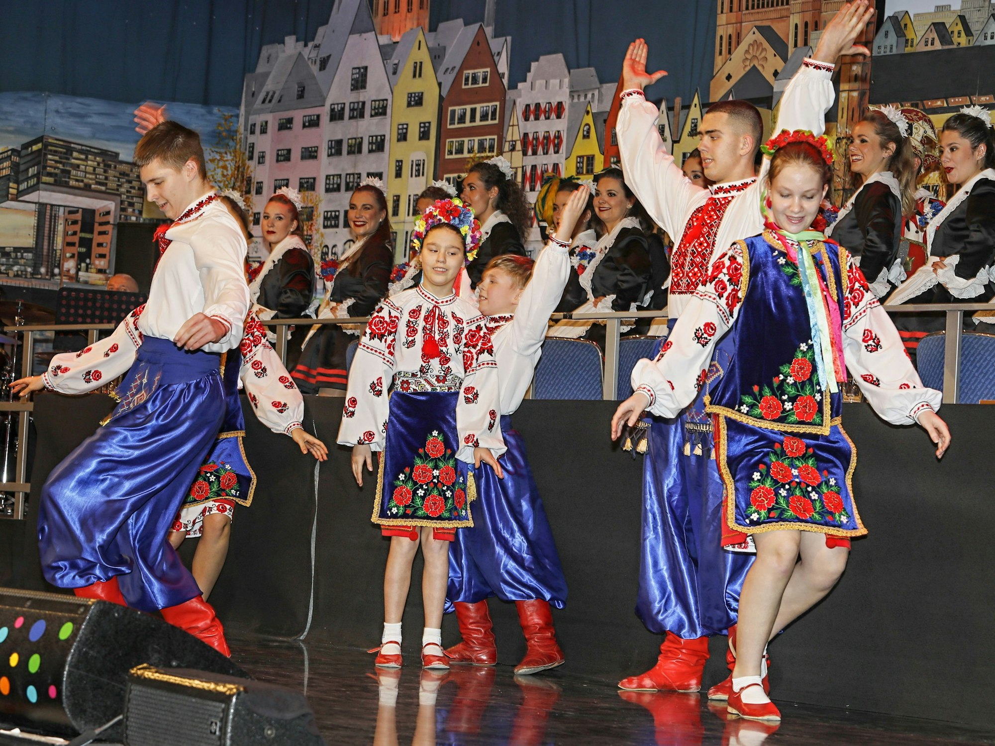 Eine Tanzgruppe steht auf einer Bühne.