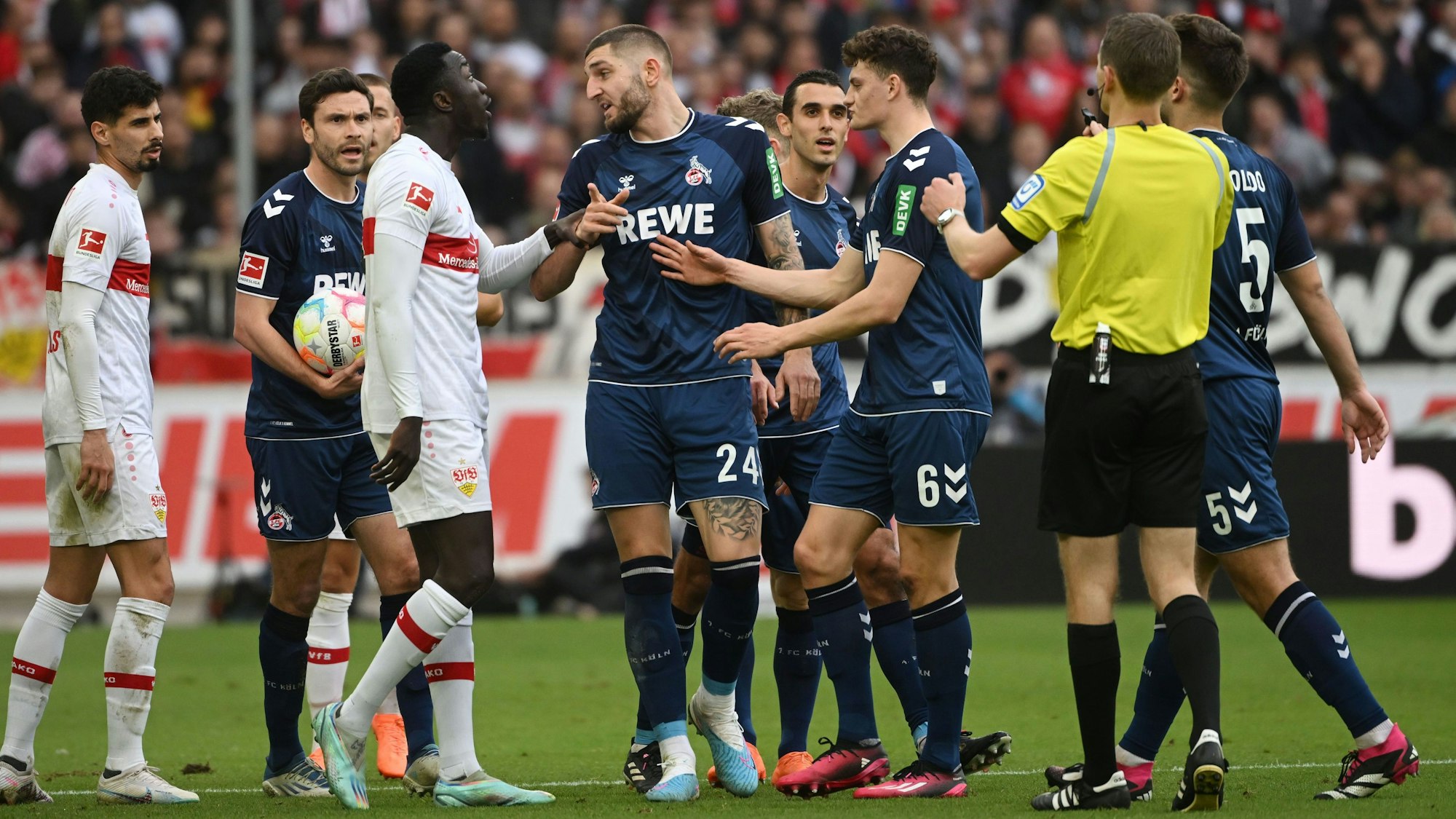 Bundesliga: Stuttgarter und Kölner Spieler diskutieren über eine Schiedsrichter-Entscheidung.