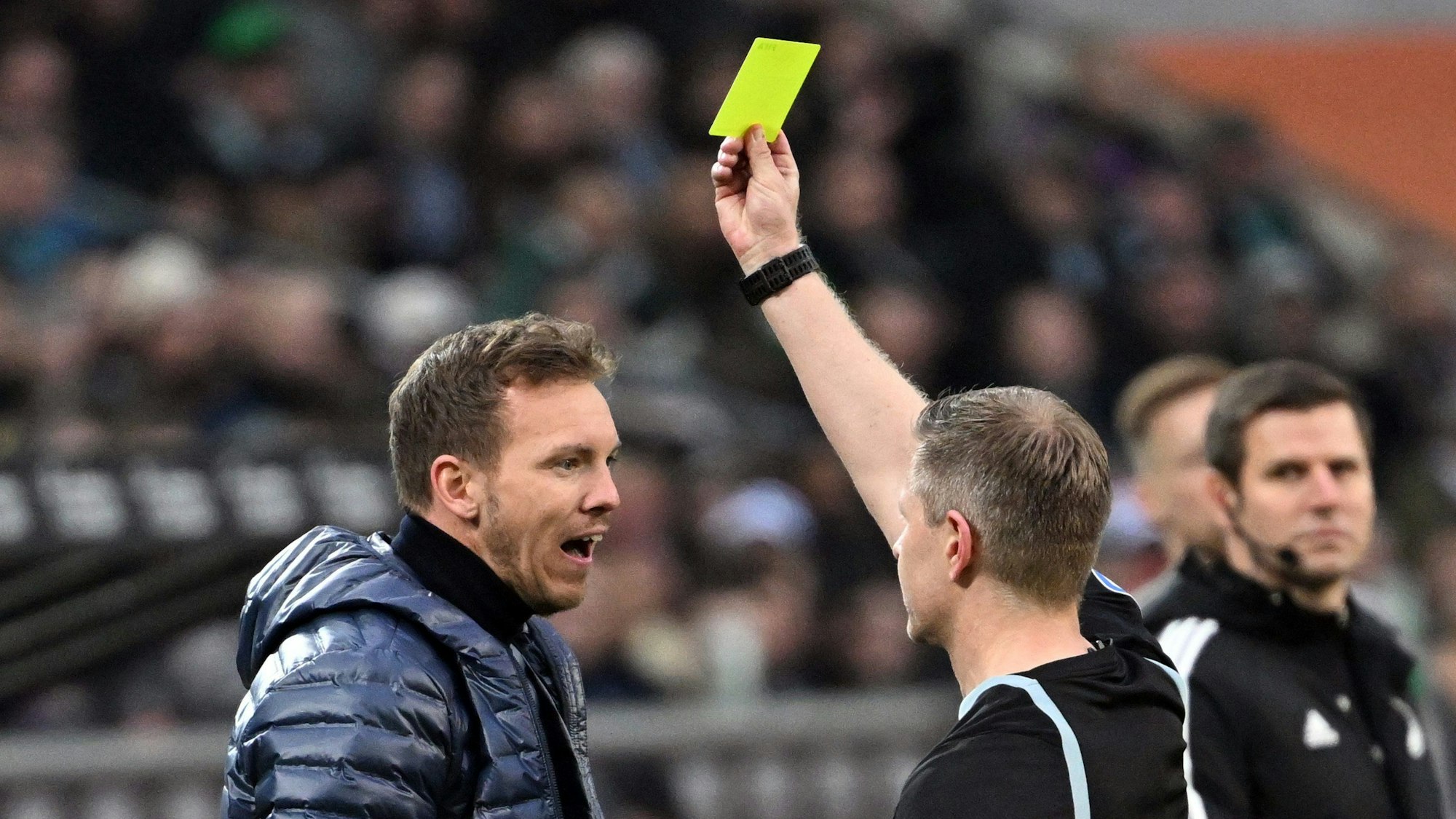 Schiedsrichter Tobias Welz zeigt Bayerns Trainer Julian Nagelsmann die Gelbe Karte.