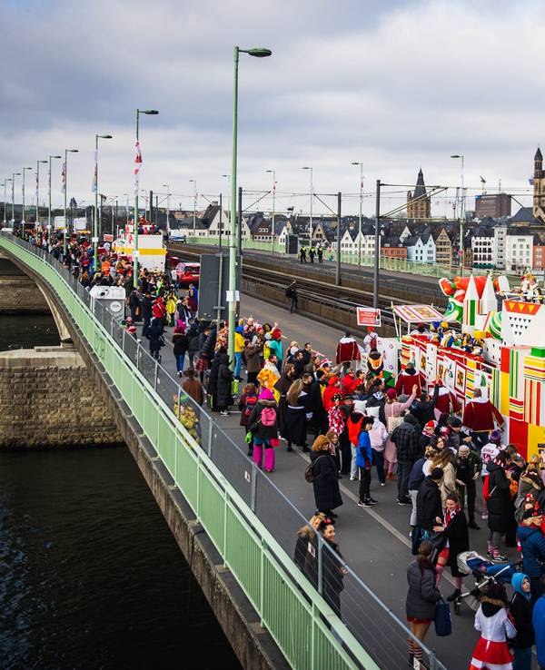 Eine Gruppe im Kölner Rosenmontagszug passiert die Deutzer Brücke, im Hintergrund der Kölner Dom.