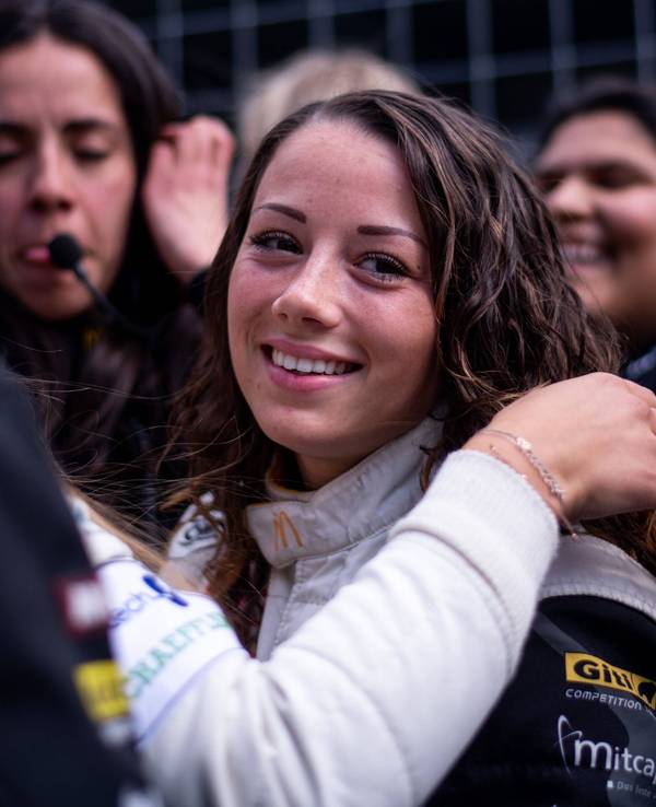Carrie Schreiner blickt beim 24-Stunden-Rennen auf dem Nürburgring in der Box in die Kamera.