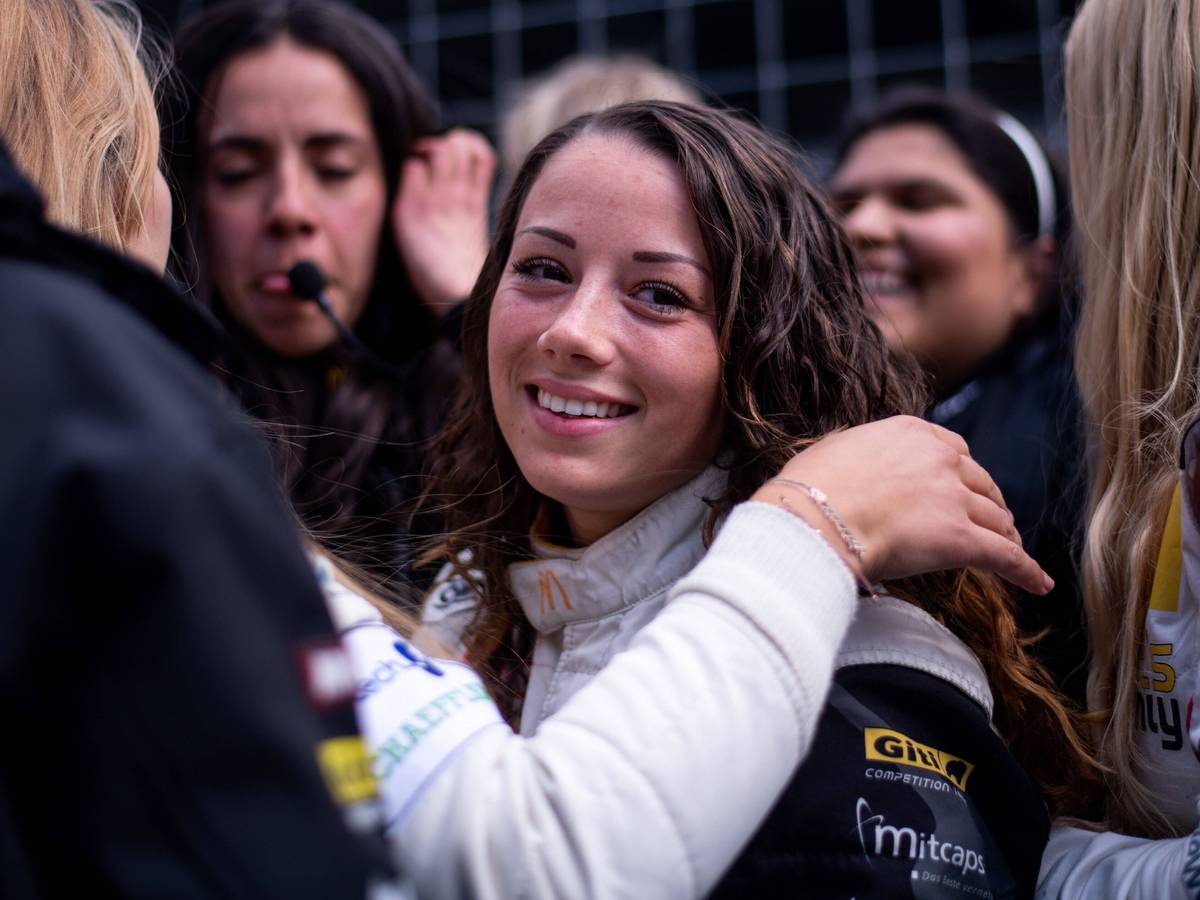 Carrie Schreiner blickt beim 24-Stunden-Rennen auf dem Nürburgring in der Box in die Kamera.
