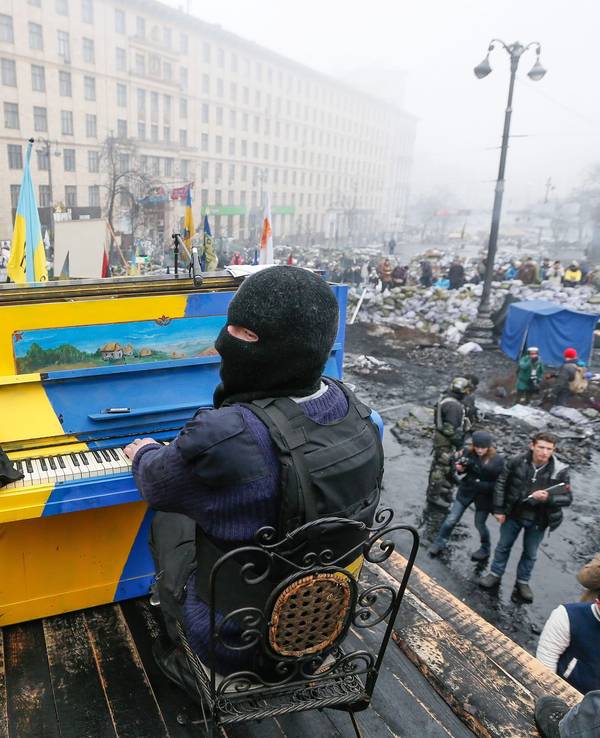 Ein am 22. November 2014 veröffentlichtes Bild aus dem Archiv zeigt einen ukrainischen Demonstranten, der während der anhaltenden Euromaidan-Proteste in Kyjiw auf einer Barrikade Klavier spielt. Das Klavier ist in den Nationalfarben der Ukraine gestrichen. Es liegen Trümmer drumherum.