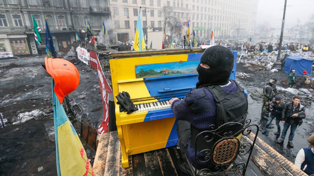 Ein am 22. November 2014 veröffentlichtes Bild aus dem Archiv zeigt einen ukrainischen Demonstranten, der während der anhaltenden Euromaidan-Proteste in Kyjiw auf einer Barrikade Klavier spielt. Das Klavier ist in den Nationalfarben der Ukraine gestrichen. Es liegen Trümmer drumherum.