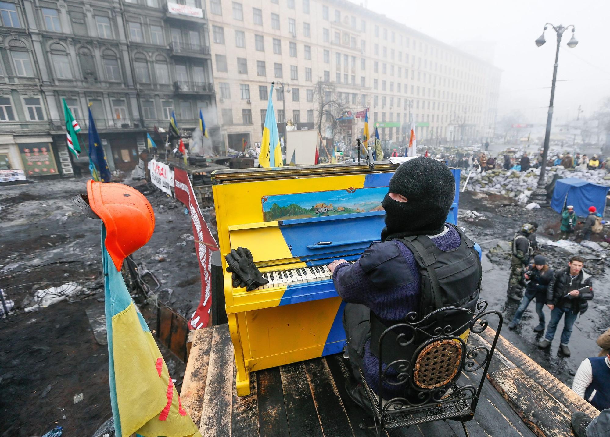 Ein am 22. November 2014 veröffentlichtes Bild aus dem Archiv zeigt einen ukrainischen Demonstranten, der während der anhaltenden Euromaidan-Proteste in Kyjiw auf einer Barrikade Klavier spielt. Das Klavier ist in den Nationalfarben der Ukraine gestrichen. Es liegen Trümmer drumherum.