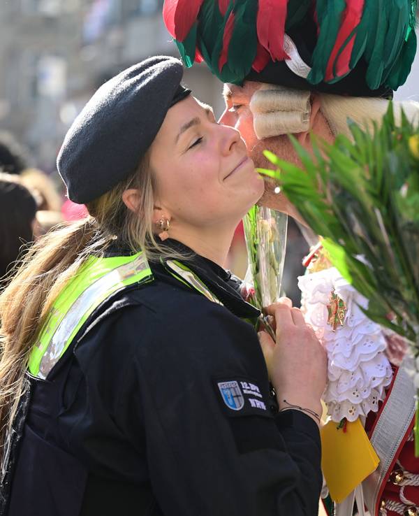 Eine Polizistin bekommt am Rande des Rosenmontagszuges ein Küsschen.
