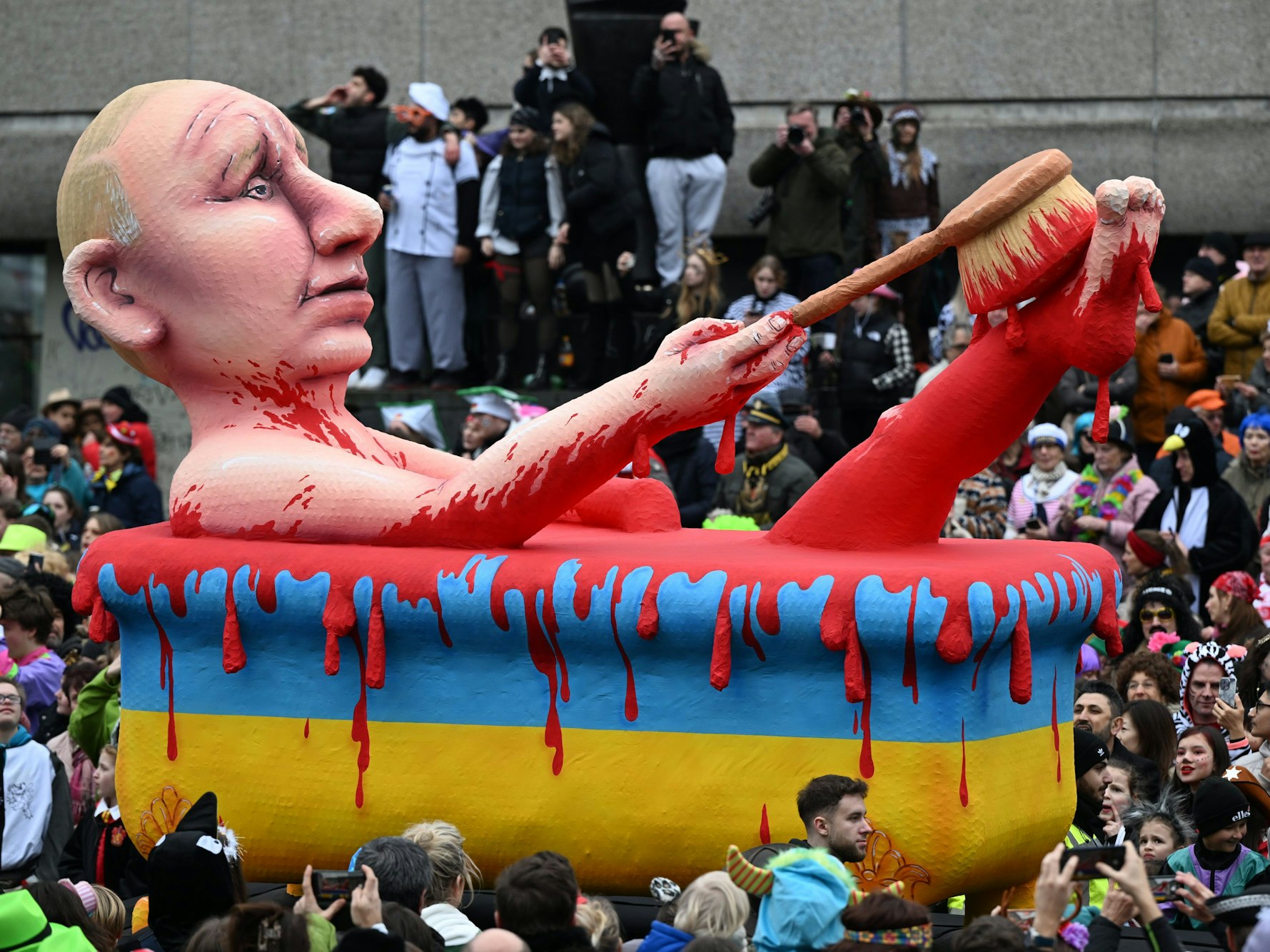 Ein Mottowagen zeigt den russischen Präsidenten Putin, der in einer Badewanne in den ukrainischen Nationalfarben ein "Blutbad" nimmt.