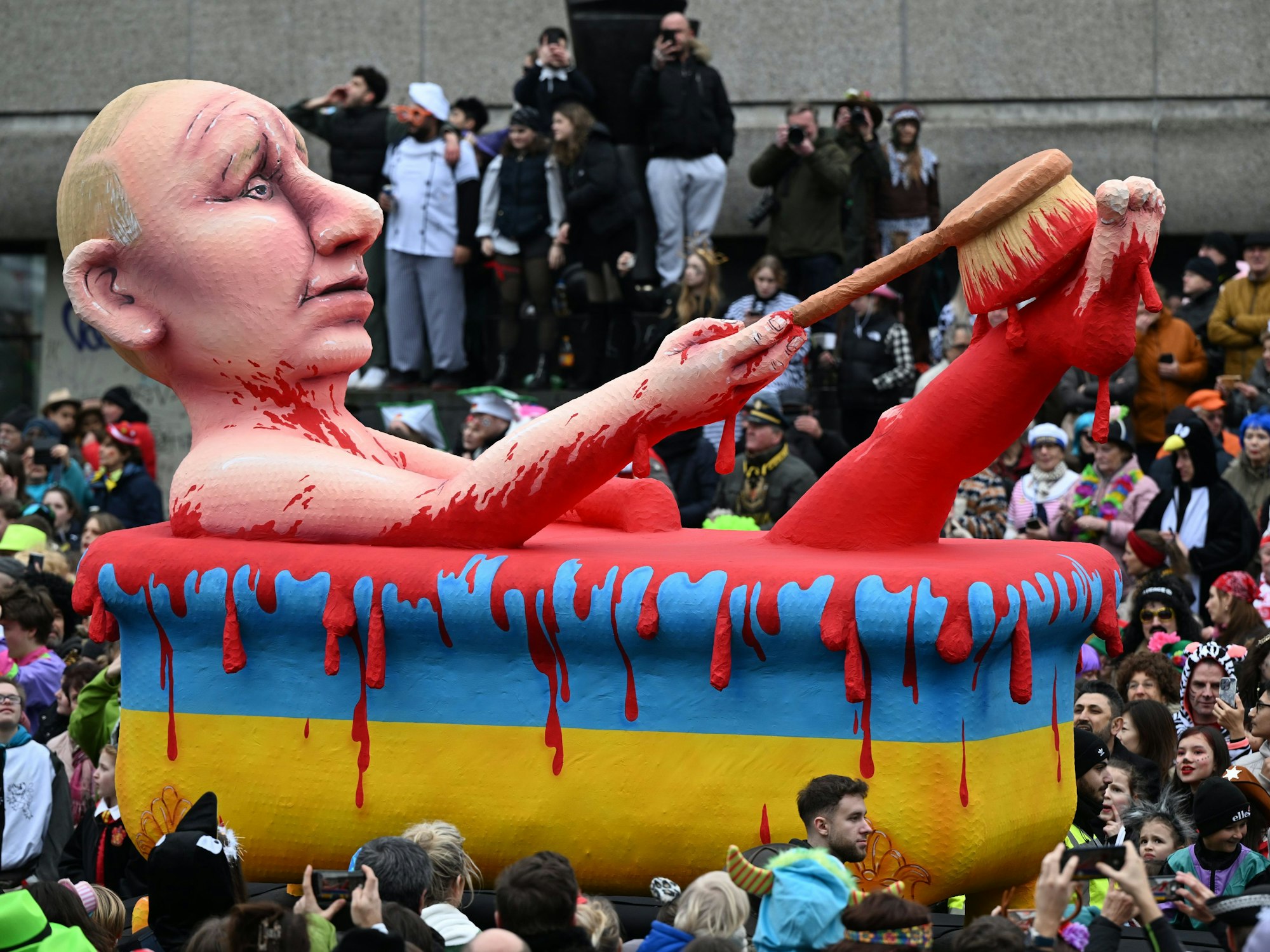 Ein Mottowagen zeigt den russischen Präsidenten Putin, der in einer Badewanne in den ukrainischen Nationalfarben ein "Blutbad" nimmt.