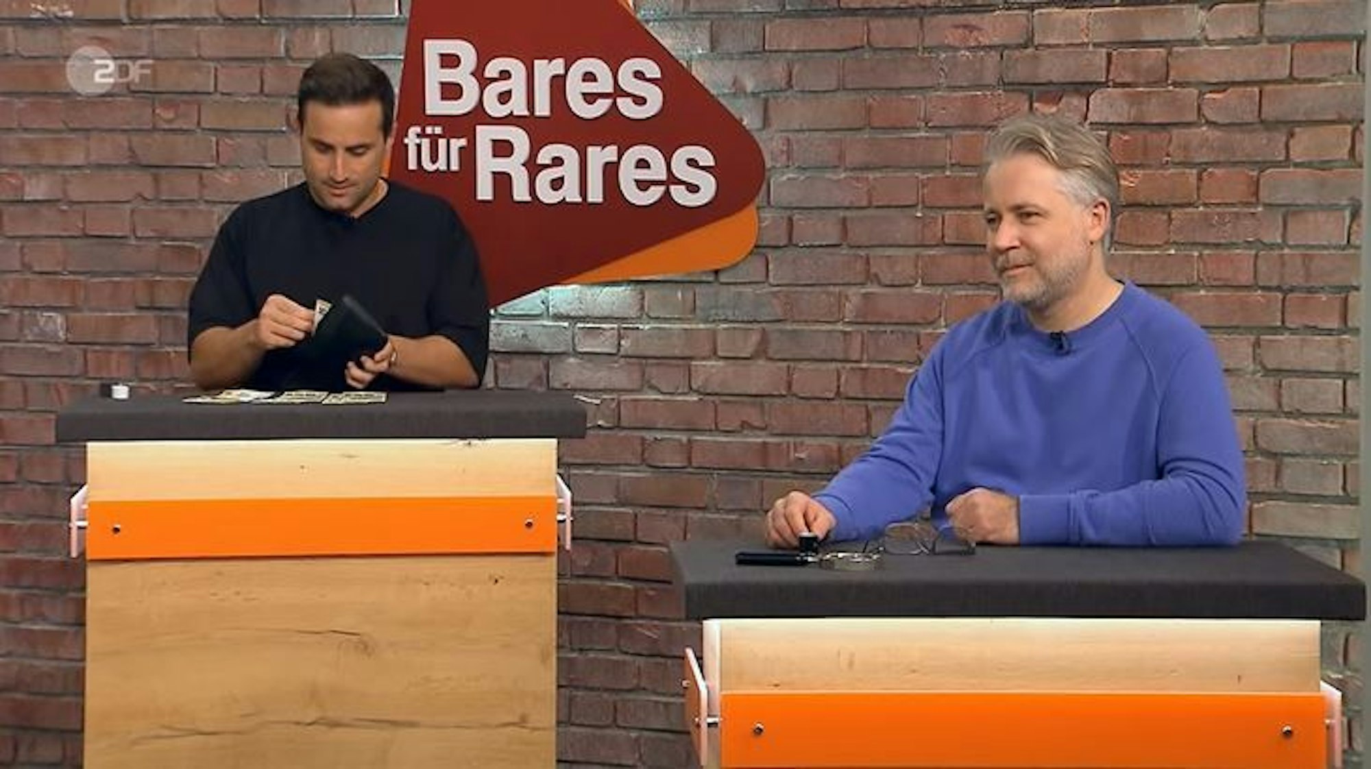 David Suppes (l.) zahlt die Geldscheine zusammen, die er für eine chinesische Robe hinblättern muss. Kollege Jan Cizek schaut zu.