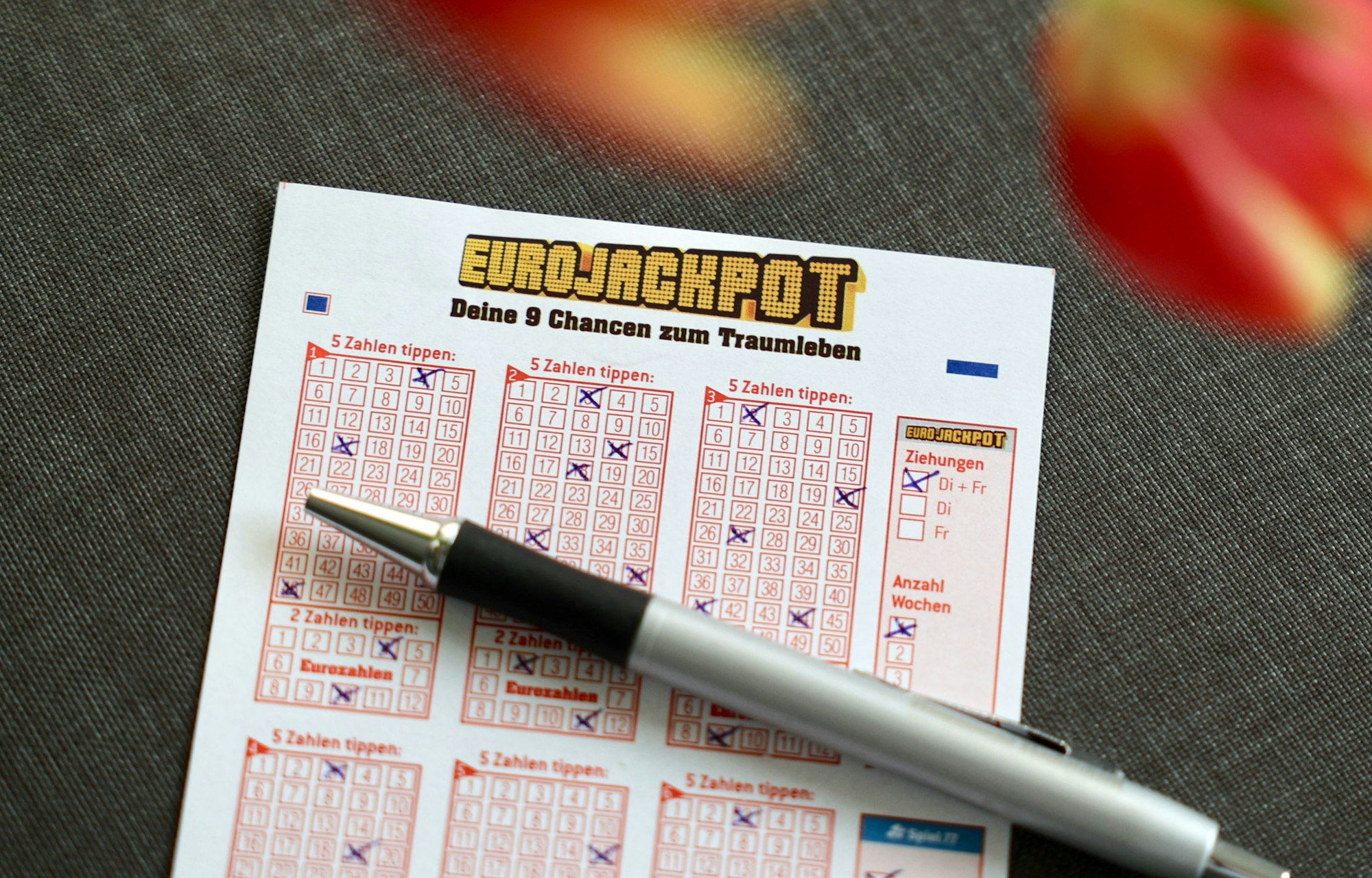 Ausgefüllter Eurojackpot Tippschein auf dem Tisch.