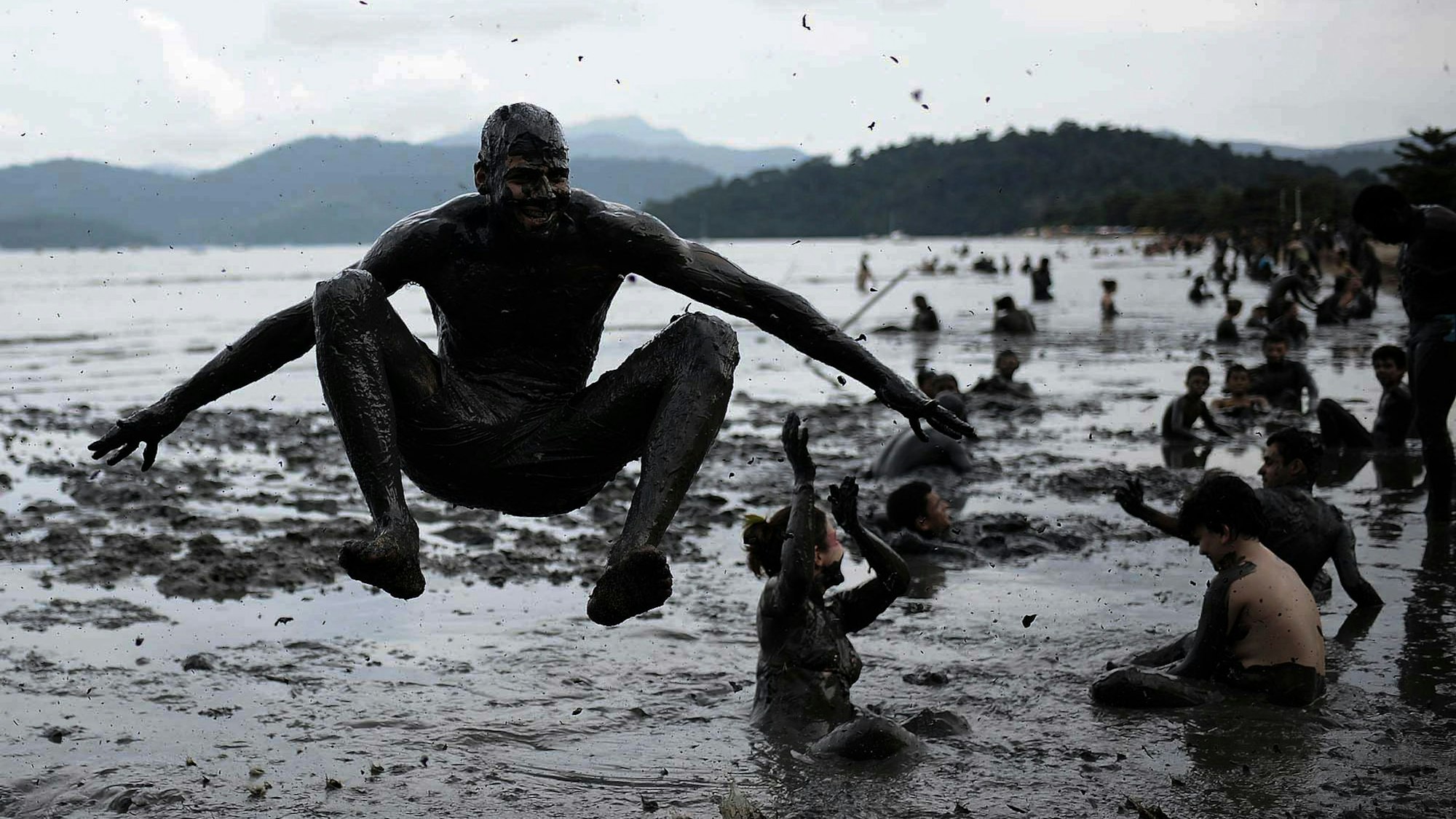 Menschen baden im Schlamm.