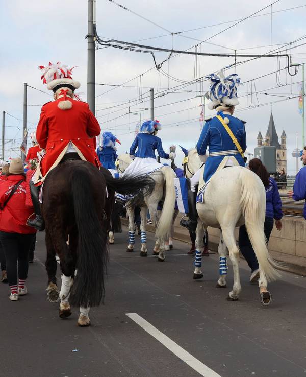 Funken reiten während des Rosenmontagszuges mit Pferden über die Deutzer Brücke.