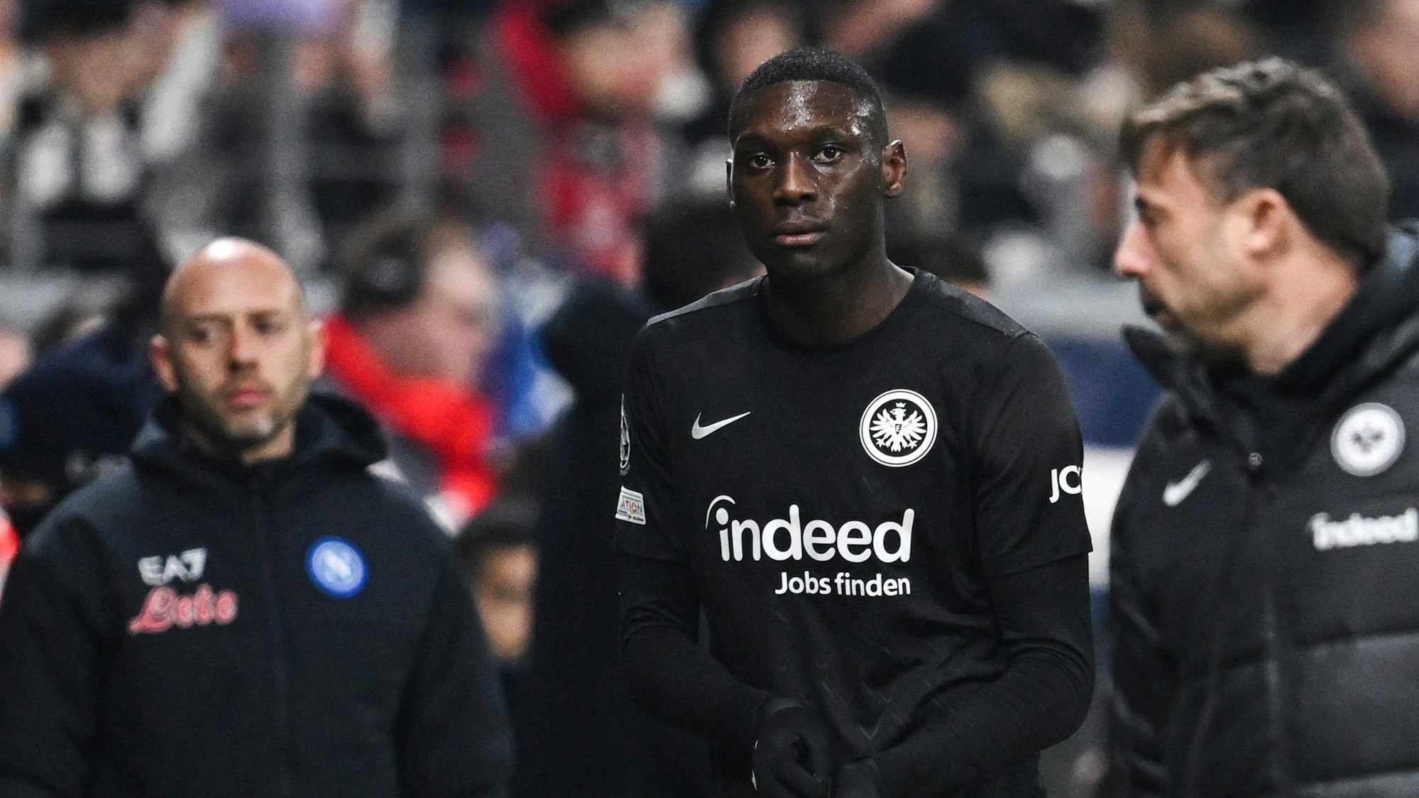 Randal Kolo Muani humpelt nach seiner Roten Karte gegen Neapel frustriert vom Platz.