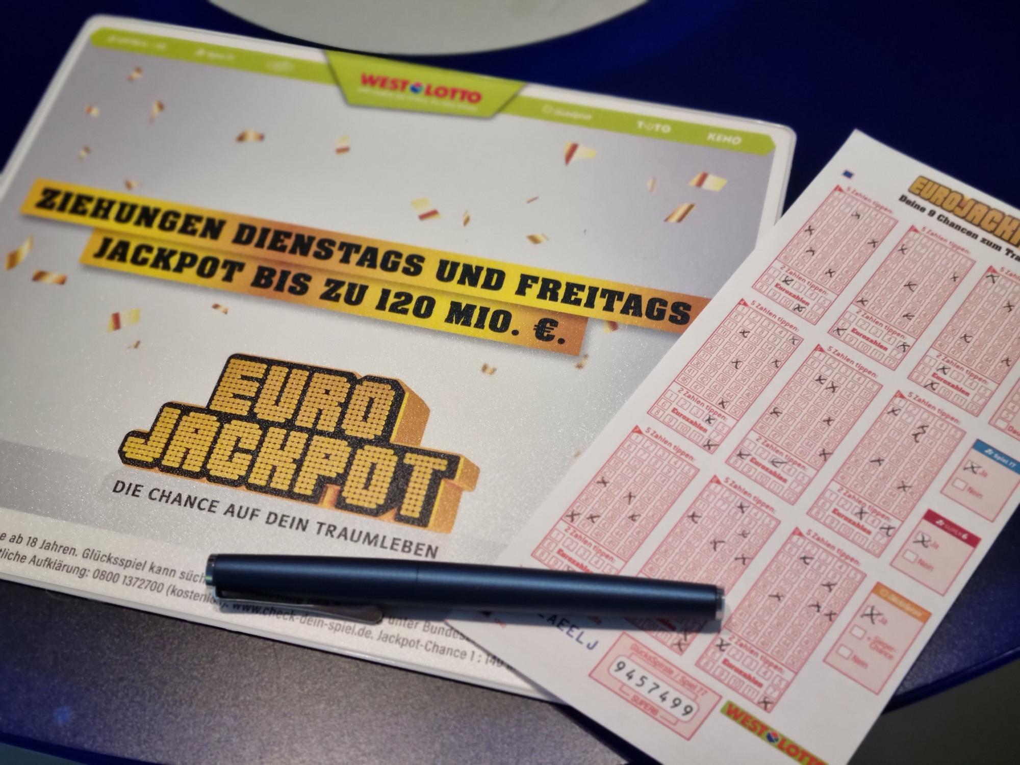 Ausgefüllter Eurojackpot Tippschein liegt auf einer Eurojackpot Schreibunterlage.