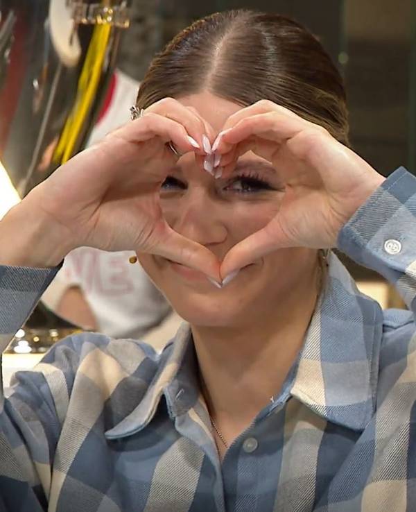 Sport1-Moderatorin Jana Wosnitza bildet mit ihren Händen ein Herz.