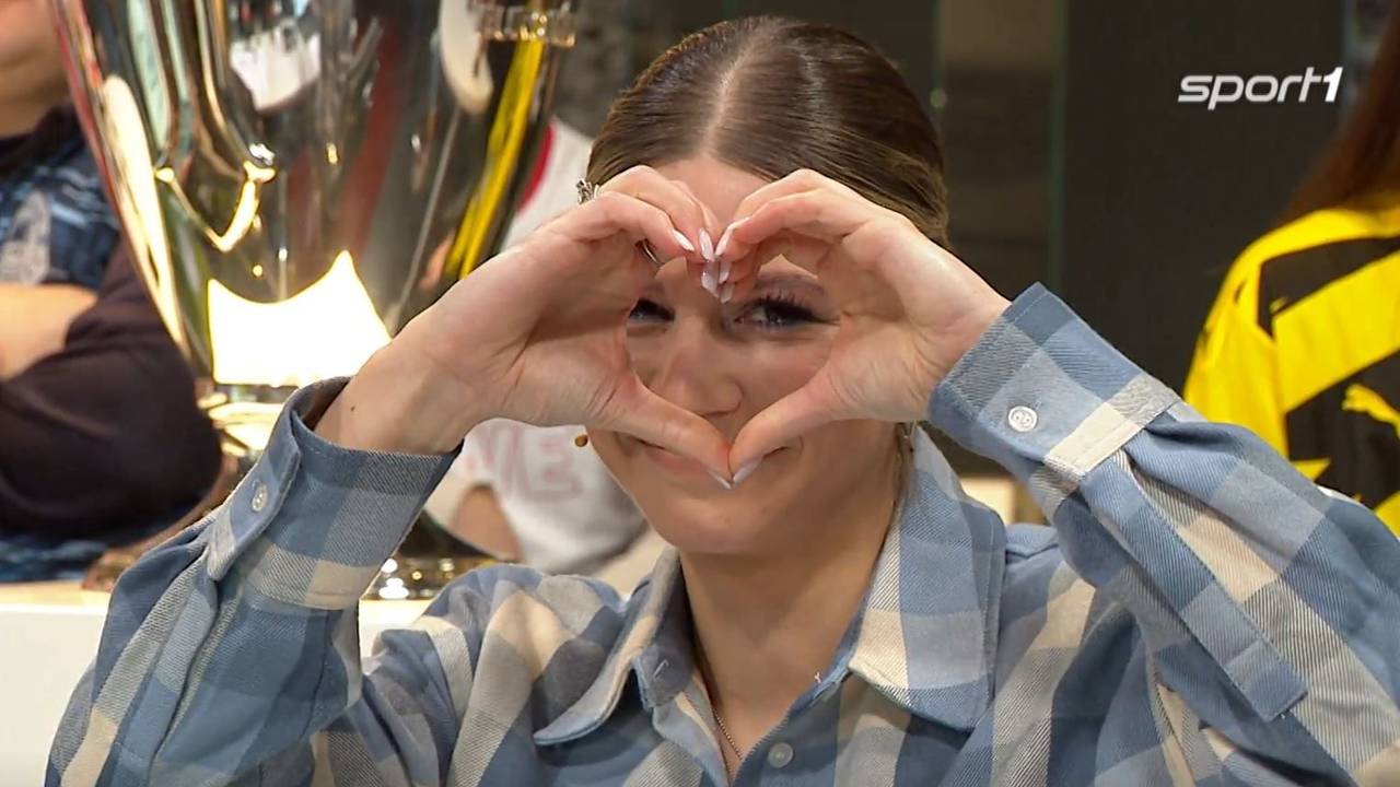 Sport1-Moderatorin Jana Wosnitza bildet mit ihren Händen ein Herz.