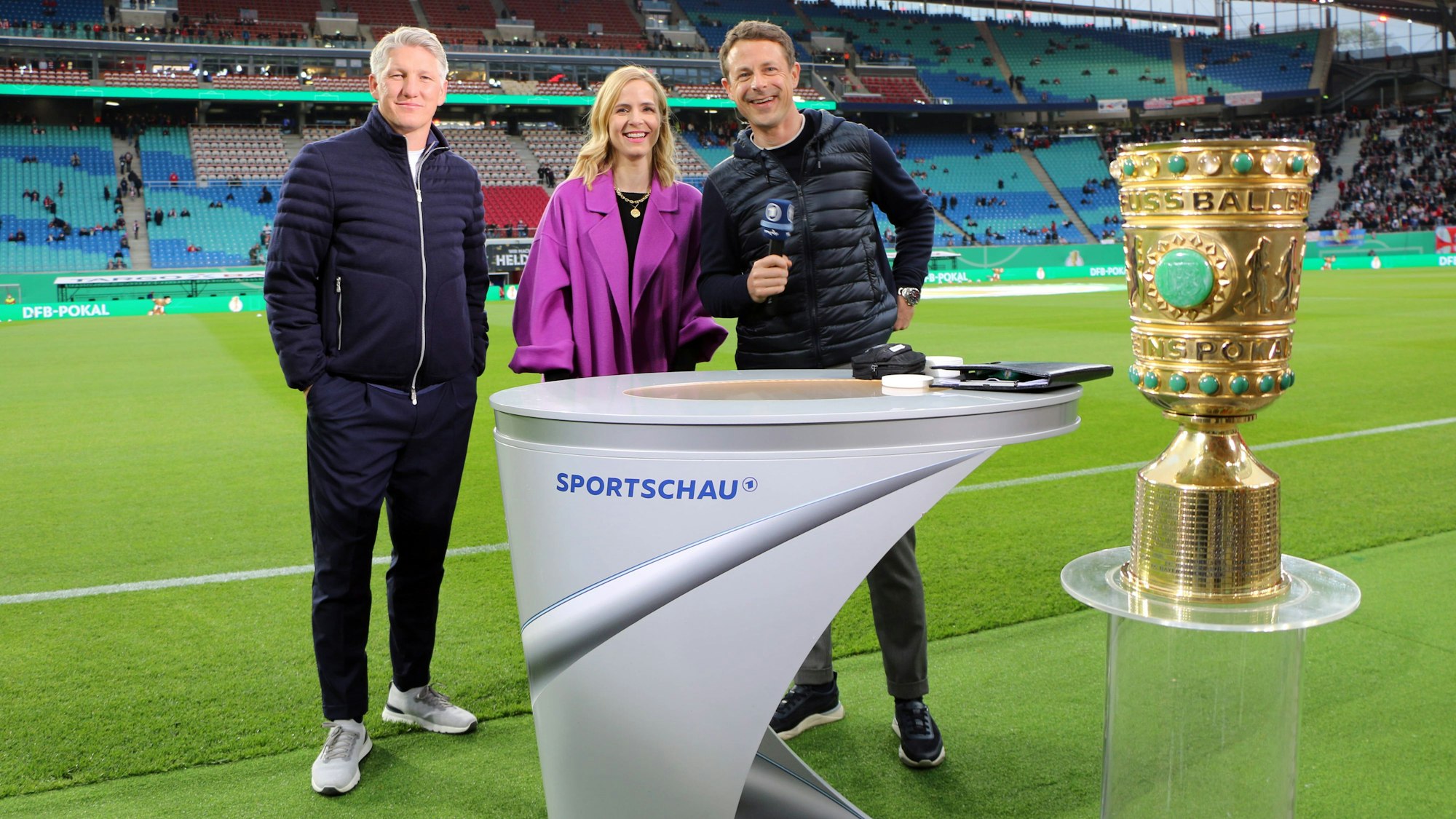 Bastian Schweinsteiger (l.) Stephanie Müller-Spirra (M.) und Alexander Bommes schauen fröhlich in die Kamera.