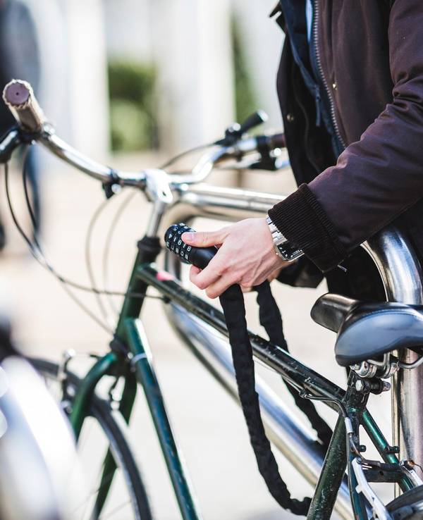 Ein Mann schließt ein Fahrradschloss auf.