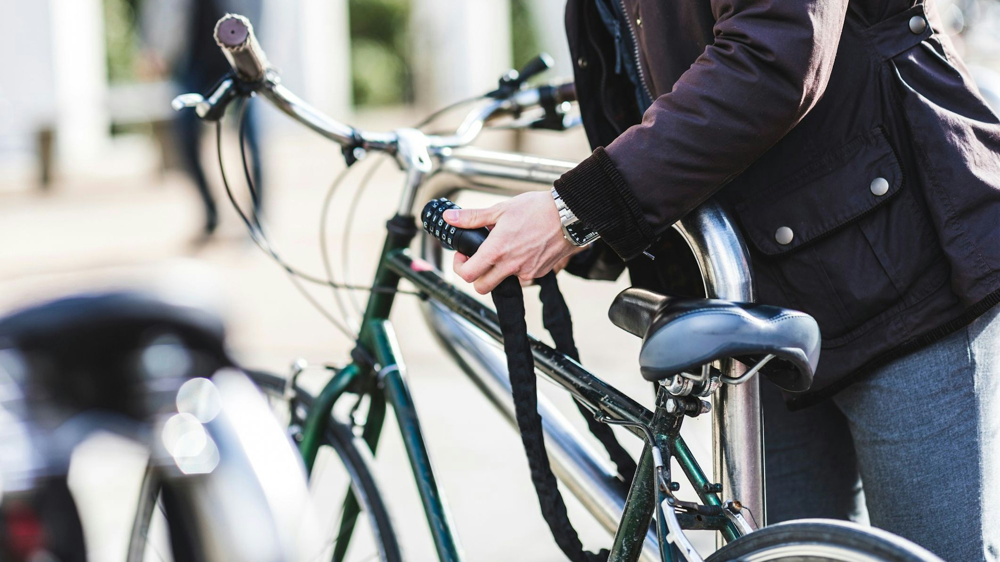 Ein Mann schließt ein Fahrradschloss auf.