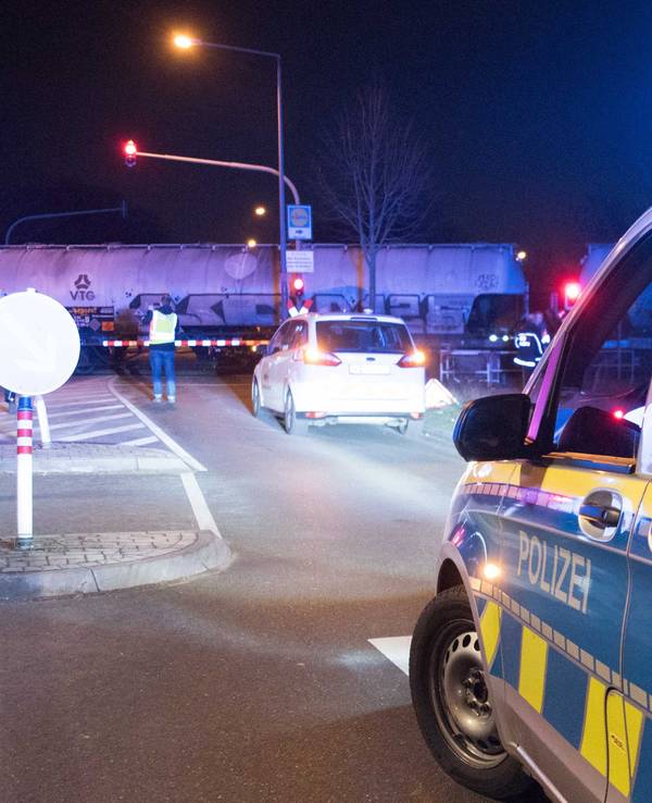 Polizei steht an einem Bahnübergang.