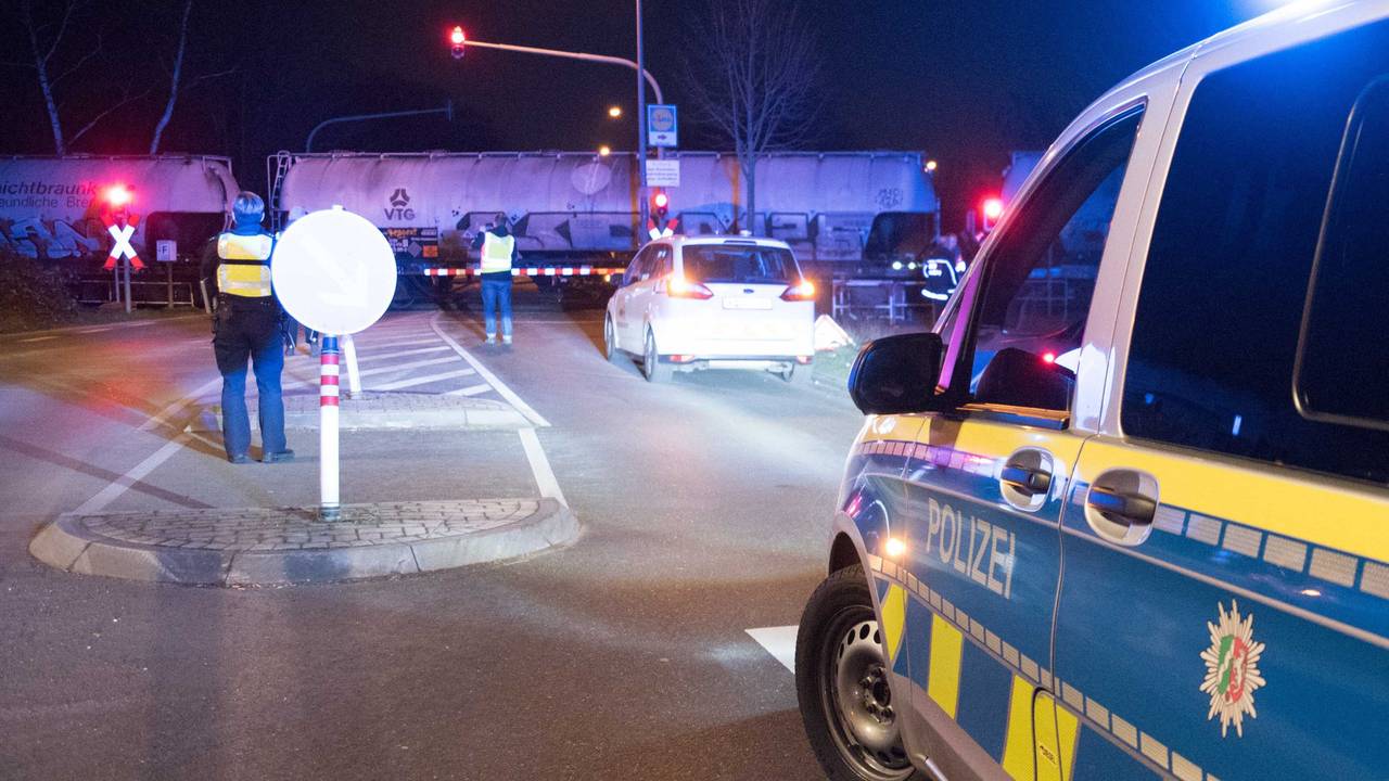 Polizei steht an einem Bahnübergang.