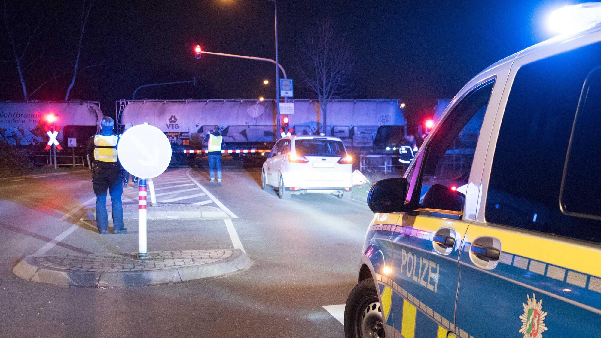 Polizei steht an einem Bahnübergang.