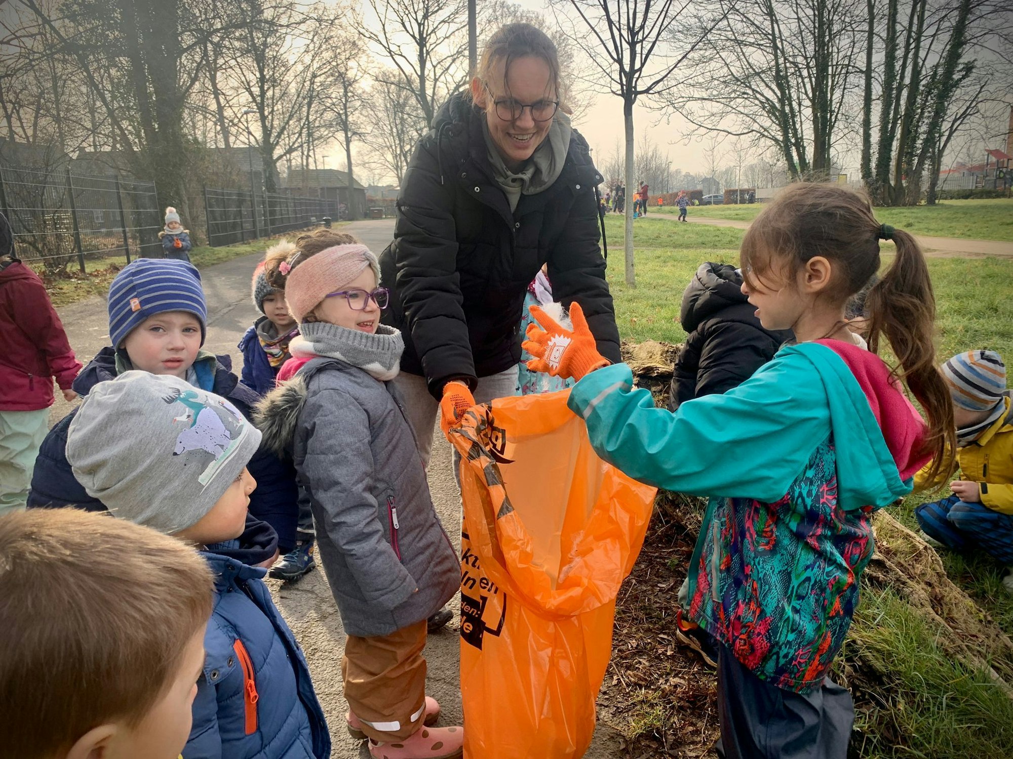 Kinder packen eingesammelten Müll in die dafür vorgesehenen Säcke.