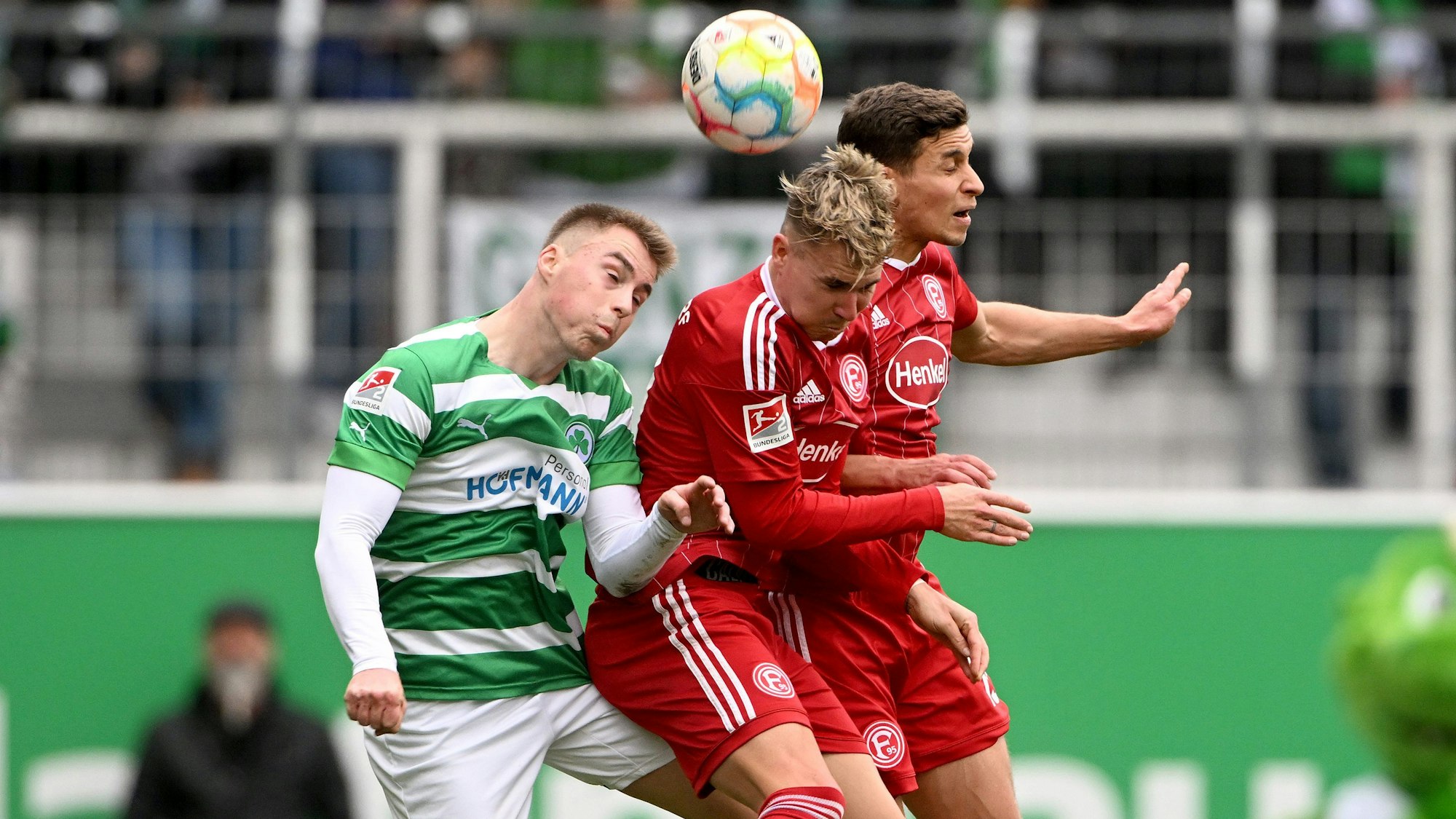 Luca Itter (l) von Greuther Fürth im Kopfballduell mit den Düsseldorfern Tim Oberdorf (r) und Felix Klaus (M).