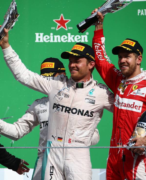Nico Rosberg und Sebastian Vettel halten ihre Trophäen in die Höhe.