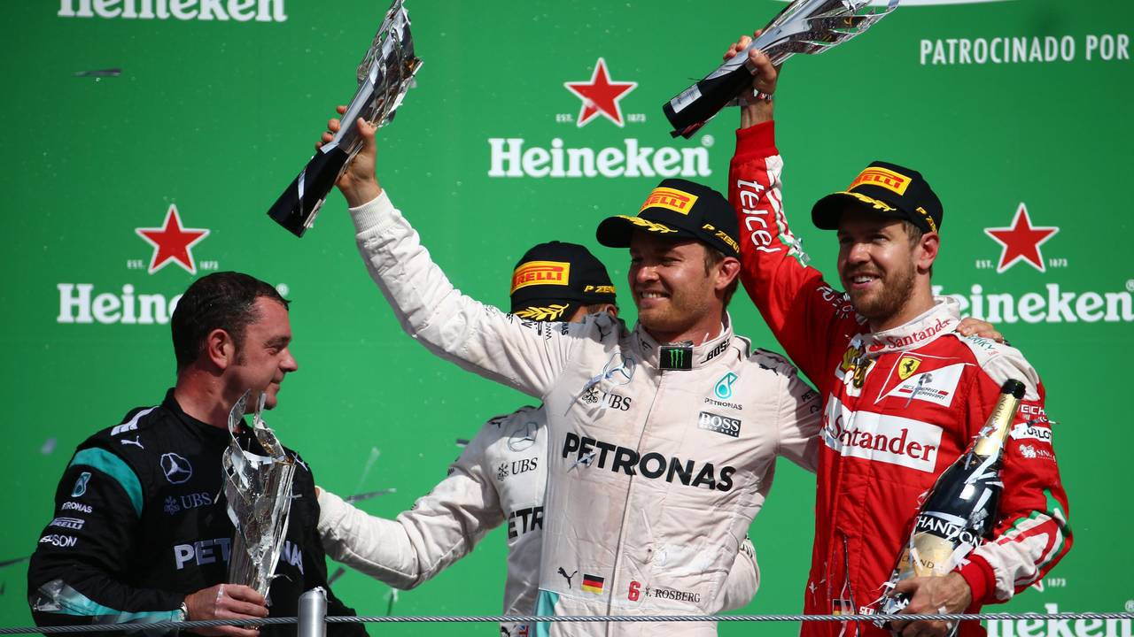 Nico Rosberg und Sebastian Vettel halten ihre Trophäen in die Höhe.