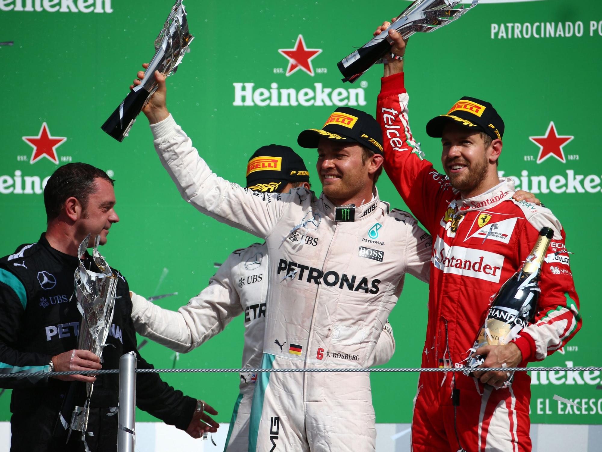 Nico Rosberg und Sebastian Vettel halten ihre Trophäen in die Höhe.