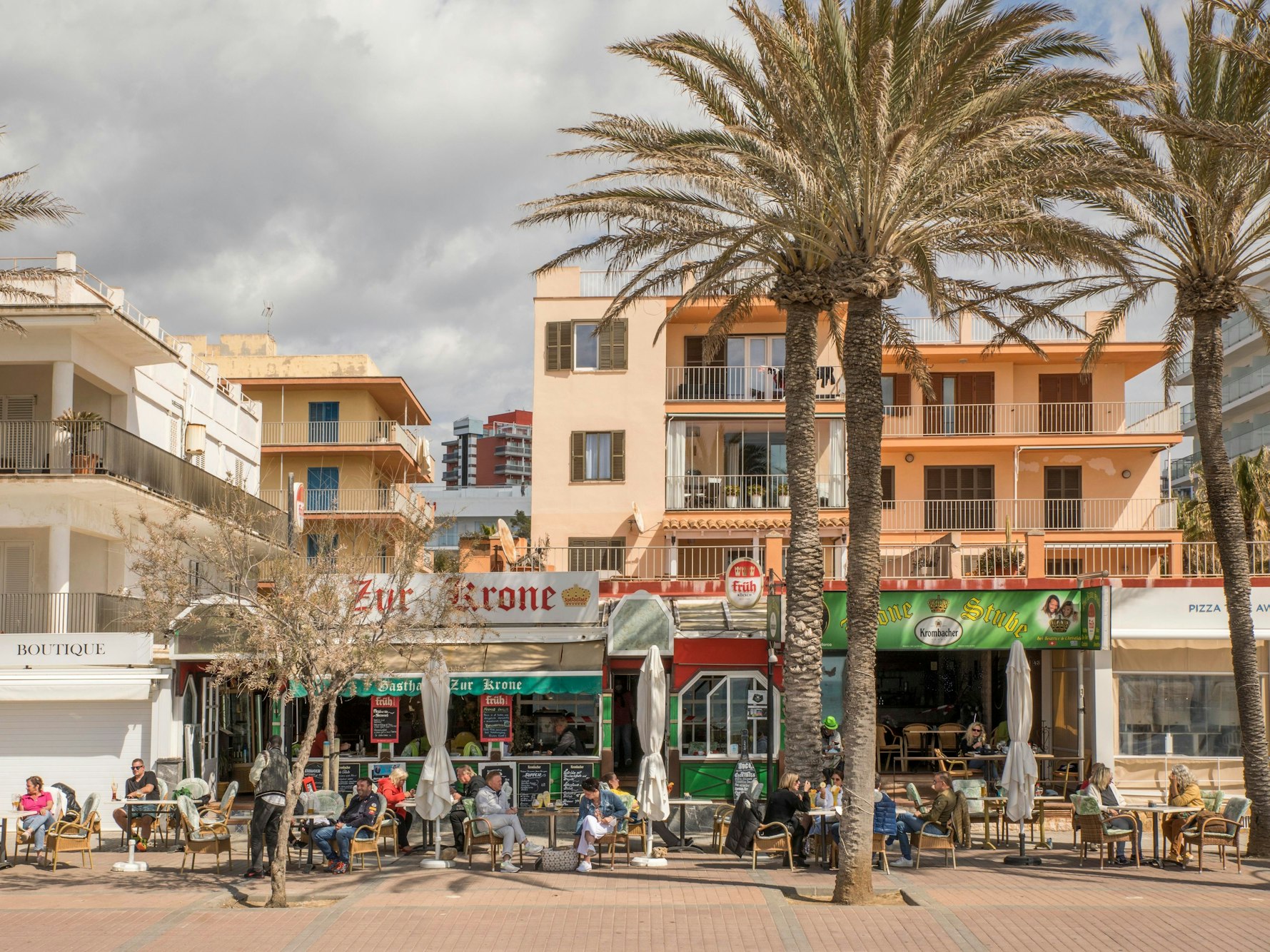 Deutsche Touristen sitzen in der bekannten Bar Zur Krone & Krone Stube und genießen einen Drink in der Sonne an der Playa de Palma auf Mallorca.