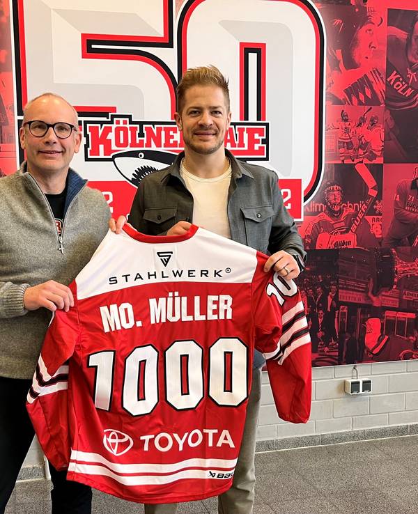 Mirko Lüdemann und Moritz Müller zeigen das Haie-Trikot mit der 1000.