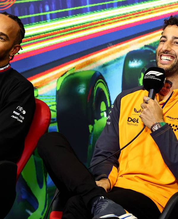 Daniel Ricciardo (r.) sitzt bei einer Pressekonferenz in einem orangen McLaren-Oberteil neben Lewis Hamilton, Formel-1-Fahrer bei Mercedes. Beide Fahrer lachen. Das Foto wurde im Rahmen des Großen Preis von Italien in Monza am 8. September 2022 aufgenommen.