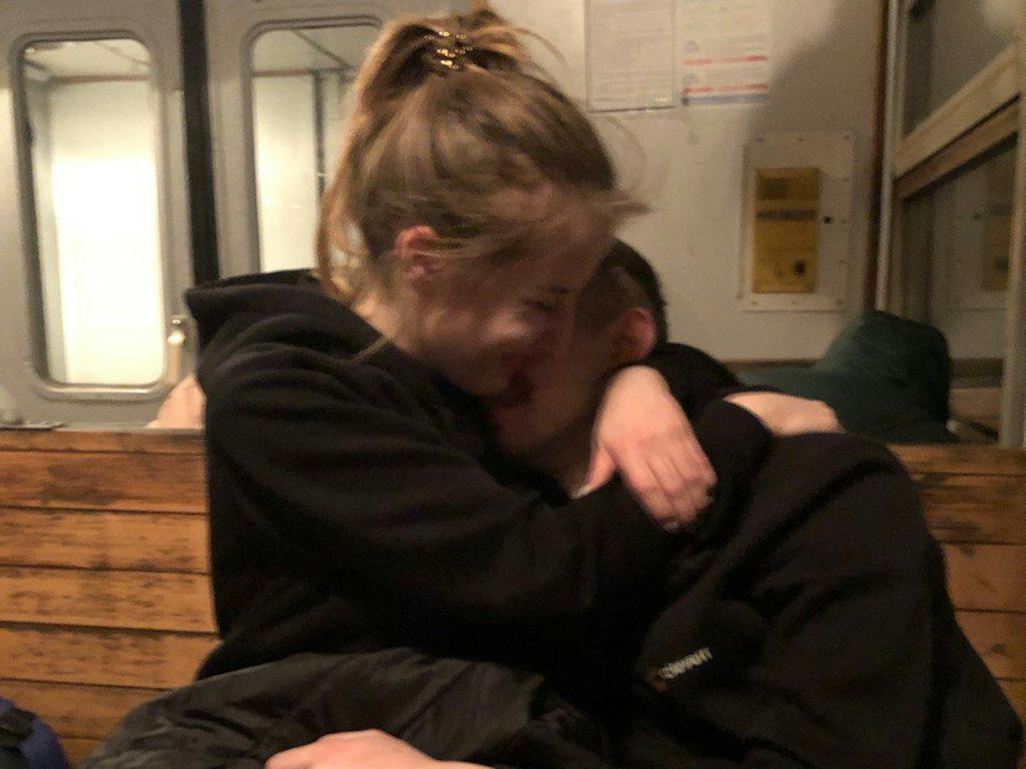 Ein junges Paar umarmt sich im Zug.