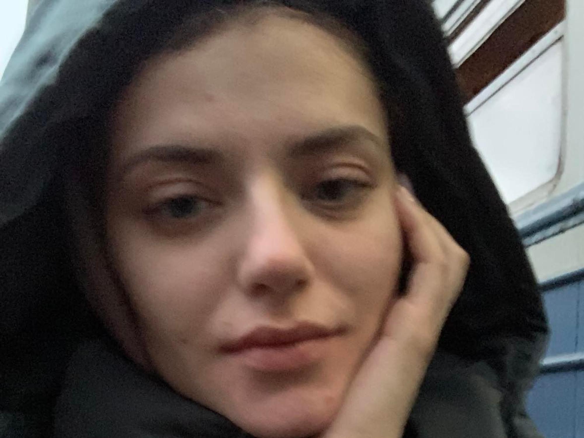 Eine junge Frau nimmt ein Selfie auf. Sie guckt müde in die Kamera.