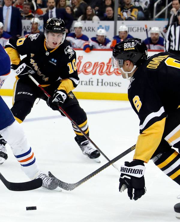 Edmontons Leon Draisaitl (l.) versucht gegen Pittsburghs Drew O'Connor (M.) und Brian Dumoulin (r.) den Puck zu behaupten.