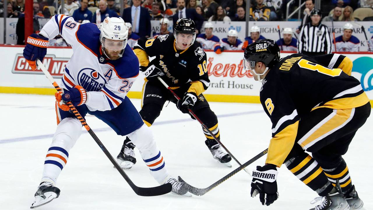 Edmontons Leon Draisaitl (l.) versucht gegen Pittsburghs Drew O'Connor (M.) und Brian Dumoulin (r.) den Puck zu behaupten.