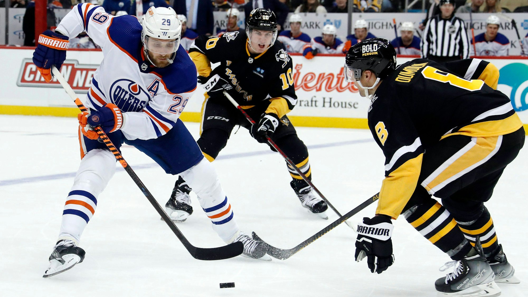 Edmontons Leon Draisaitl (l.) versucht gegen Pittsburghs Drew O'Connor (M.) und Brian Dumoulin (r.) den Puck zu behaupten.