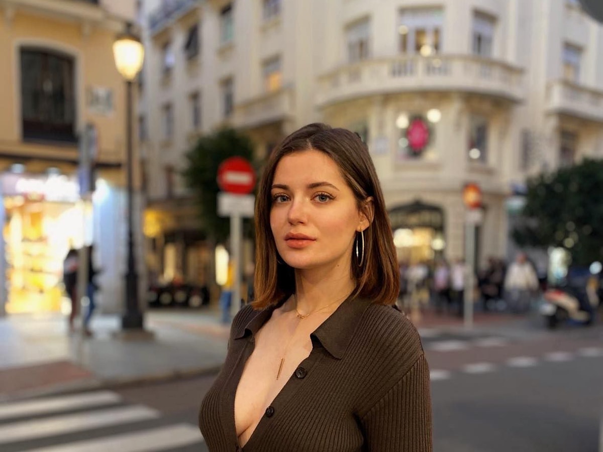 Eine junge Frau steht auf einer Straße in der ukrainischen Hauptstadt Kyjiw. Sie guckt in die Kamera.