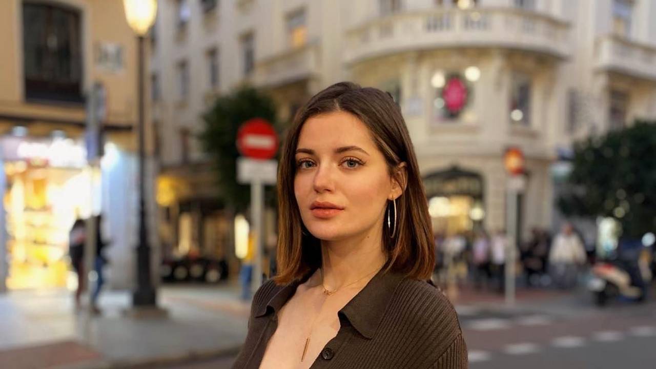 Eine junge Frau steht auf einer Straße in der ukrainischen Hauptstadt Kyjiw. Sie guckt in die Kamera.