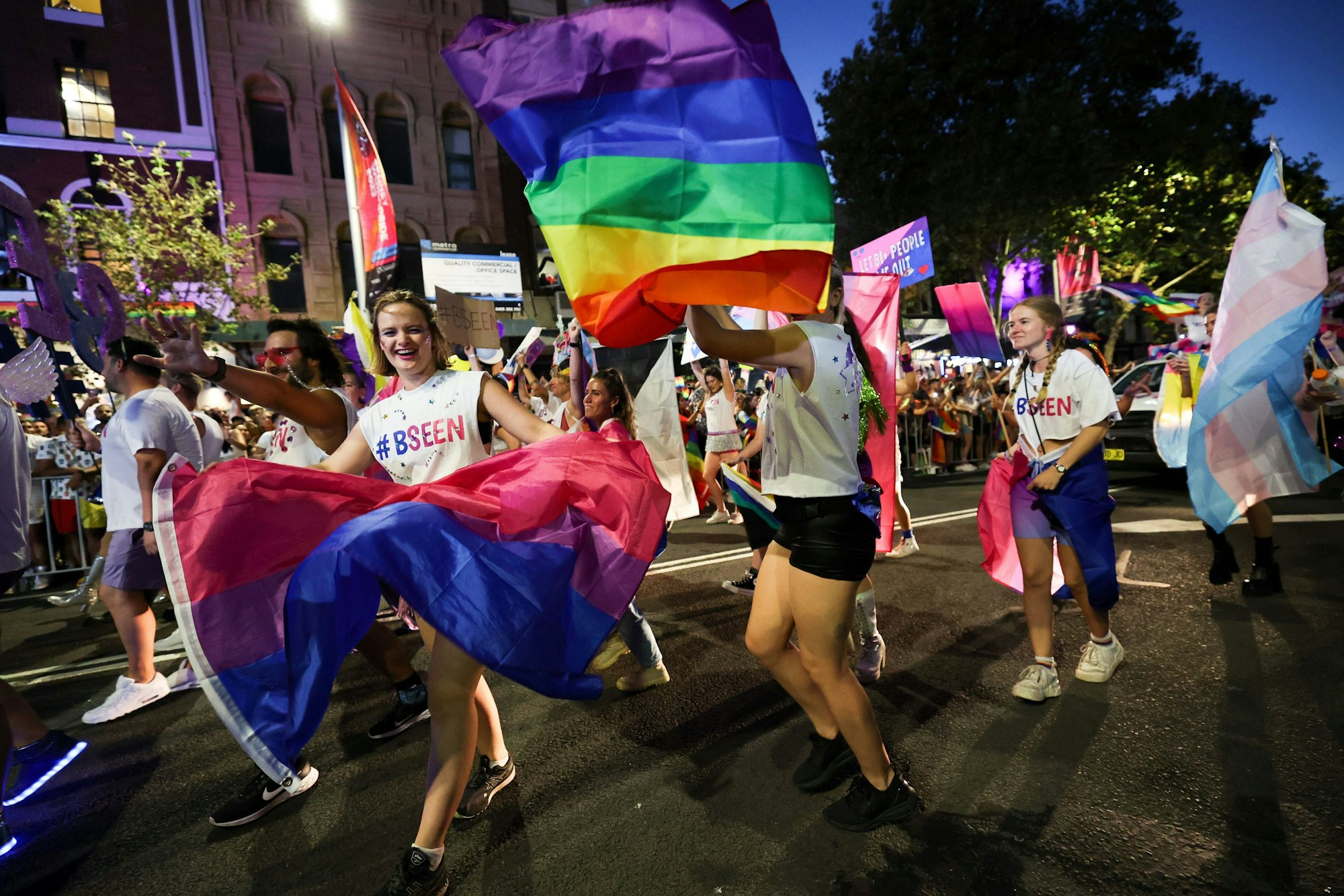 Menschen mit Regenbogenflaggen marschieren bei der 45. Mardi-Gras-Parade in Sydney mit.