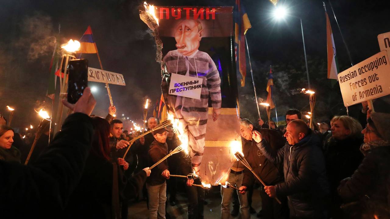 Menschen verbrennen ein Anti-Putin-Plakat mit der Aufschrift «Kriegsverbrecher» während einer Kundgebung zum ersten Jahrestag der russischen Invasion in der Ukraine. Die russische Armee hatte die Ukraine am 24.02.2022 überfallen. +++ dpa-Bildfunk +++