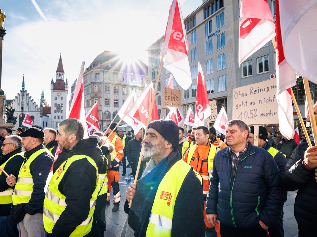 Menschen mit Verdi-Flaggen und Westen protestieren bei einem Streik für mehr Lohn.