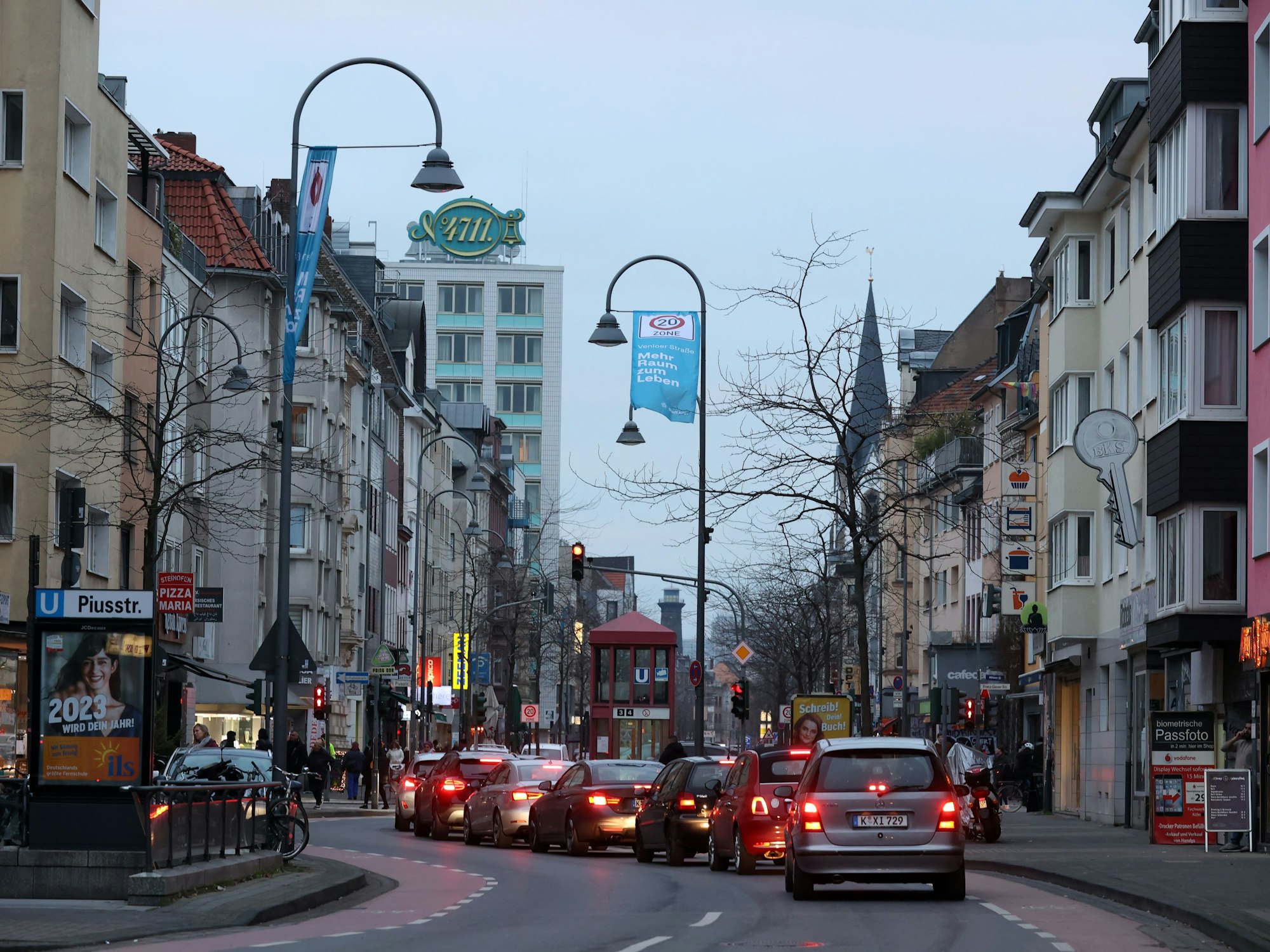Autos fahren in der Dämmerung über die Venloer Straße in Köln.