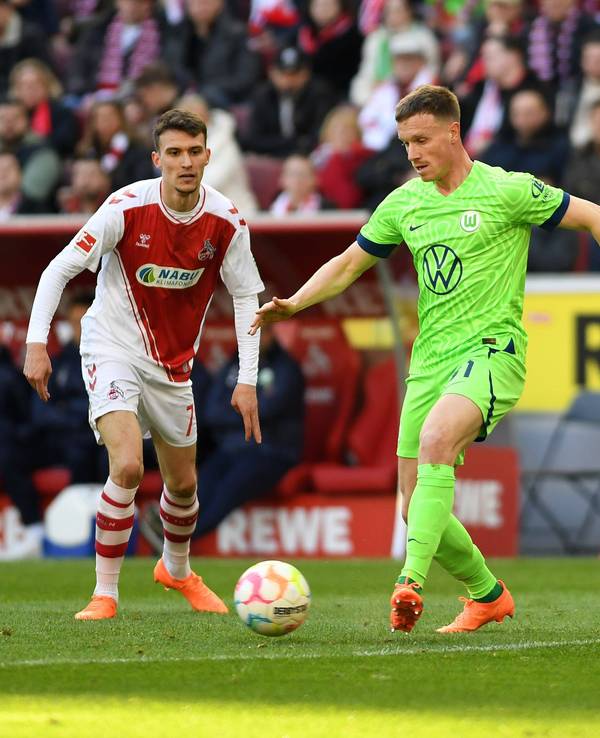 Yannick Gerhardt (M.) wird beim Bundesliga-Spiel 1. FC Köln gegen VfL Wolfsburg am Samstag (25. Februar 2023) von Dejan Ljubicic (l.) und Kingsley Schindler umringt.