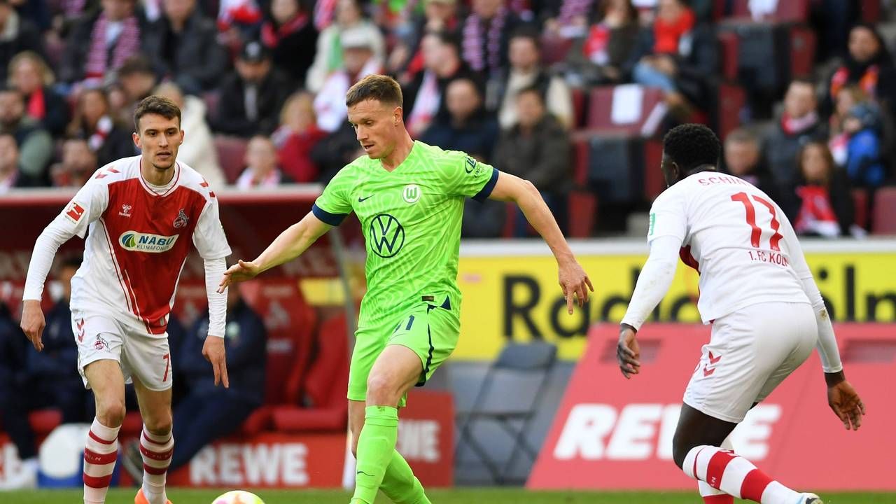 Yannick Gerhardt (M.) wird beim Bundesliga-Spiel 1. FC Köln gegen VfL Wolfsburg am Samstag (25. Februar 2023) von Dejan Ljubicic (l.) und Kingsley Schindler umringt.