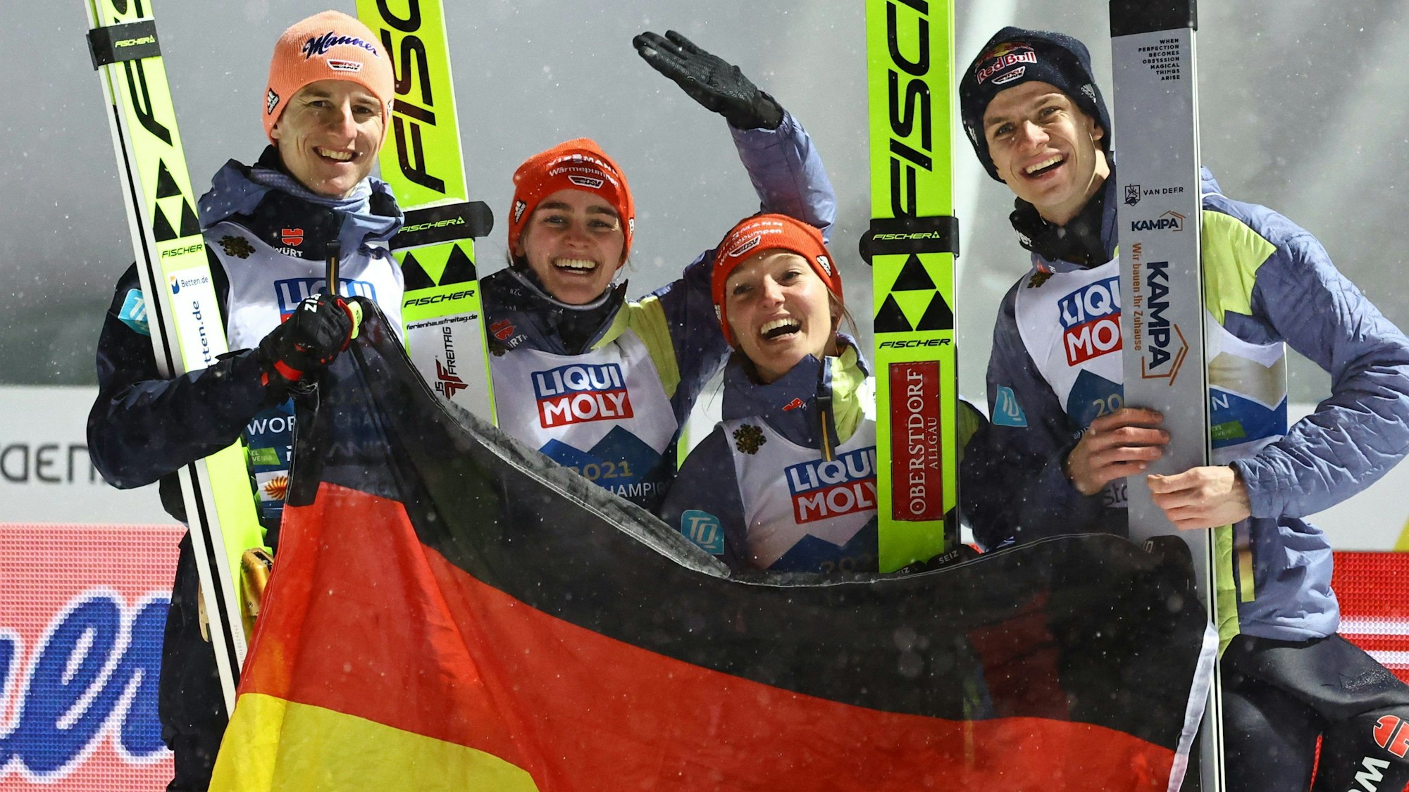 Karl Geiger, Selina Freitag, Katharina Althaus, Andreas Wellinger aus Deutschland jubeln nach Gold im Mixed-Wettbewerb.