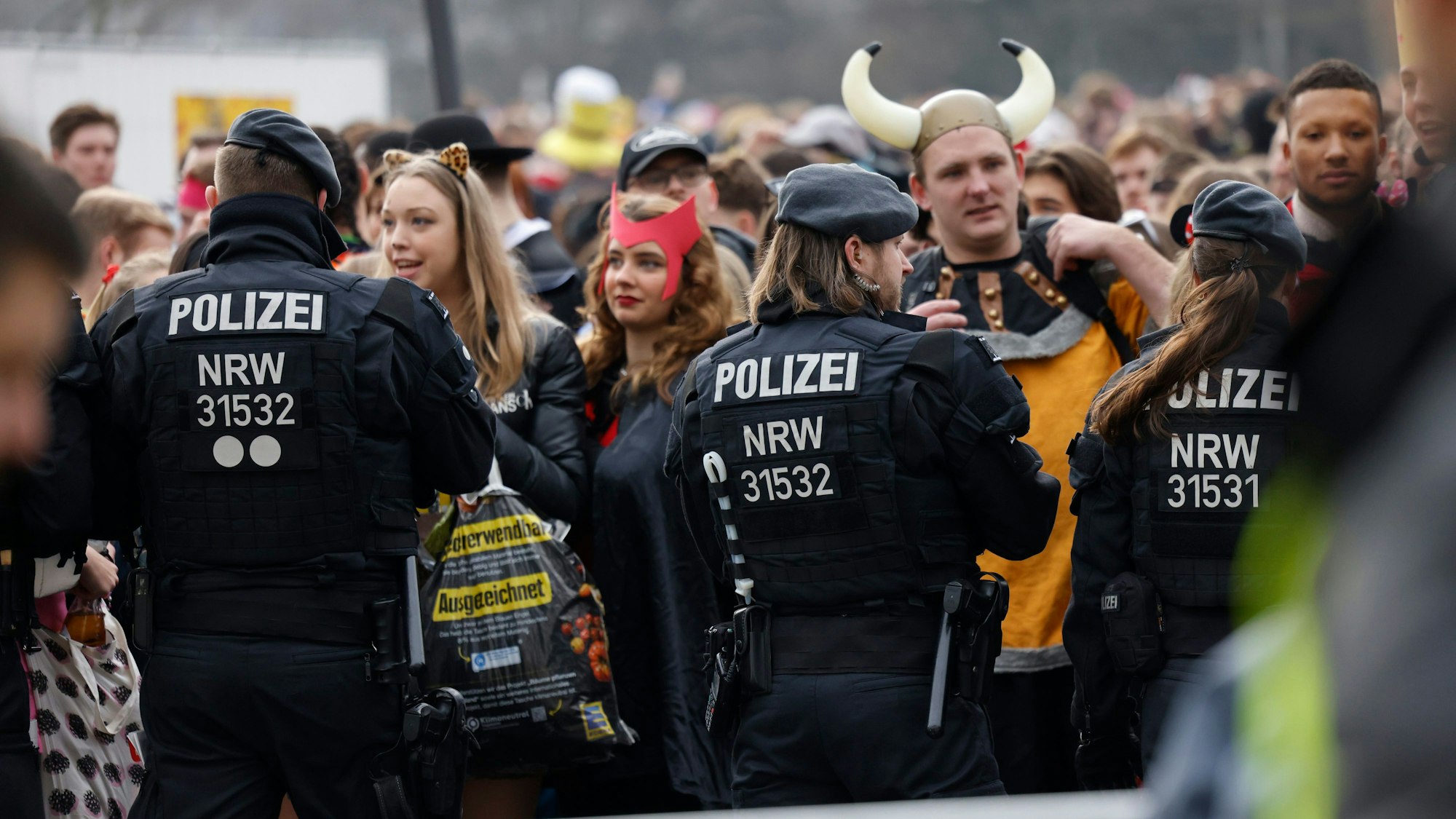 Eine Menschenmenge wartet auf den Uniwiesen am Eingang zum Zülpicher Viertel auf Einlass.