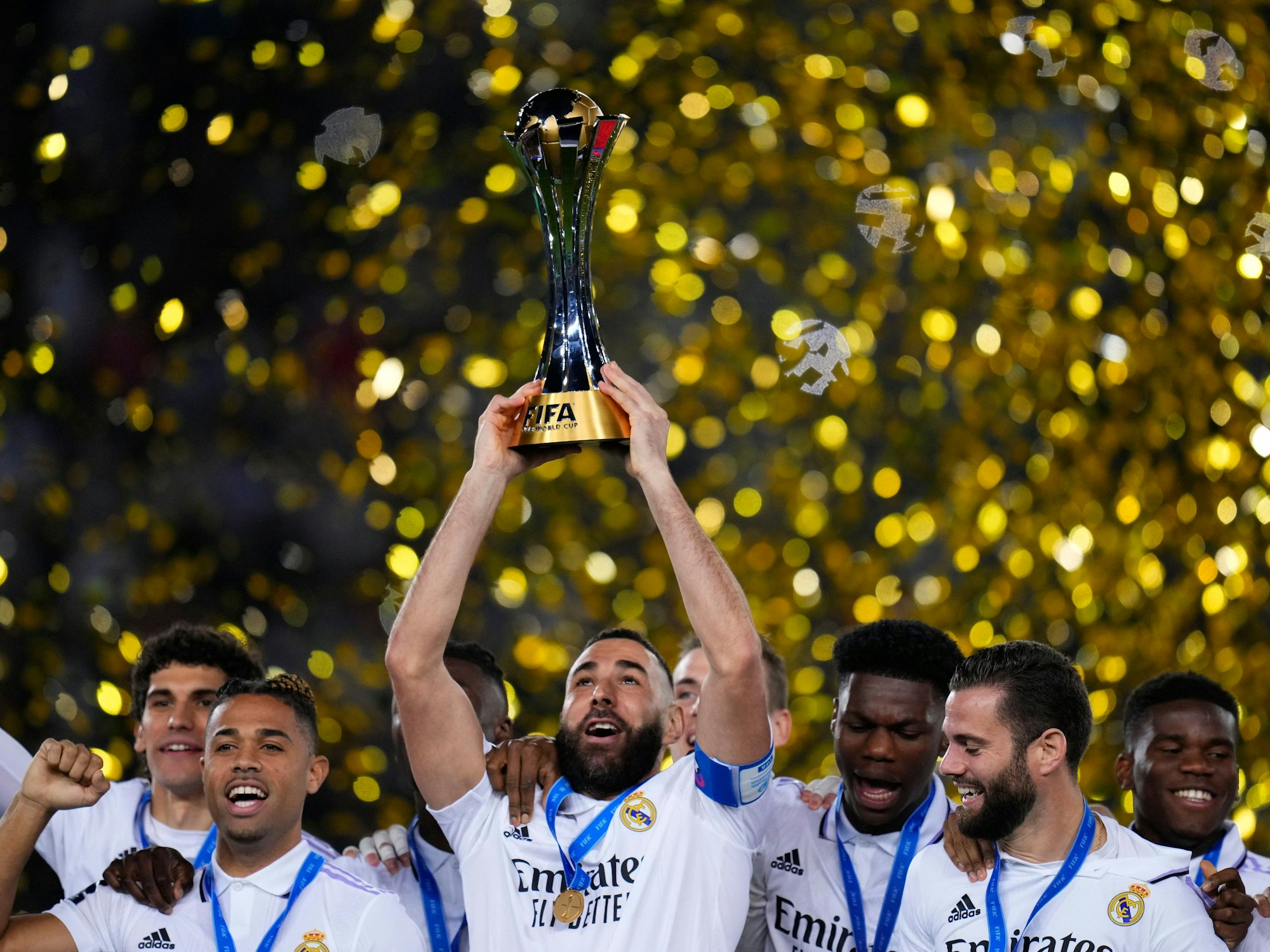 Karim Benzema (M) von Real Madrid hält den Pokal hoch, als er mit seinen Mannschaftskameraden nach dem Sieg feiert.